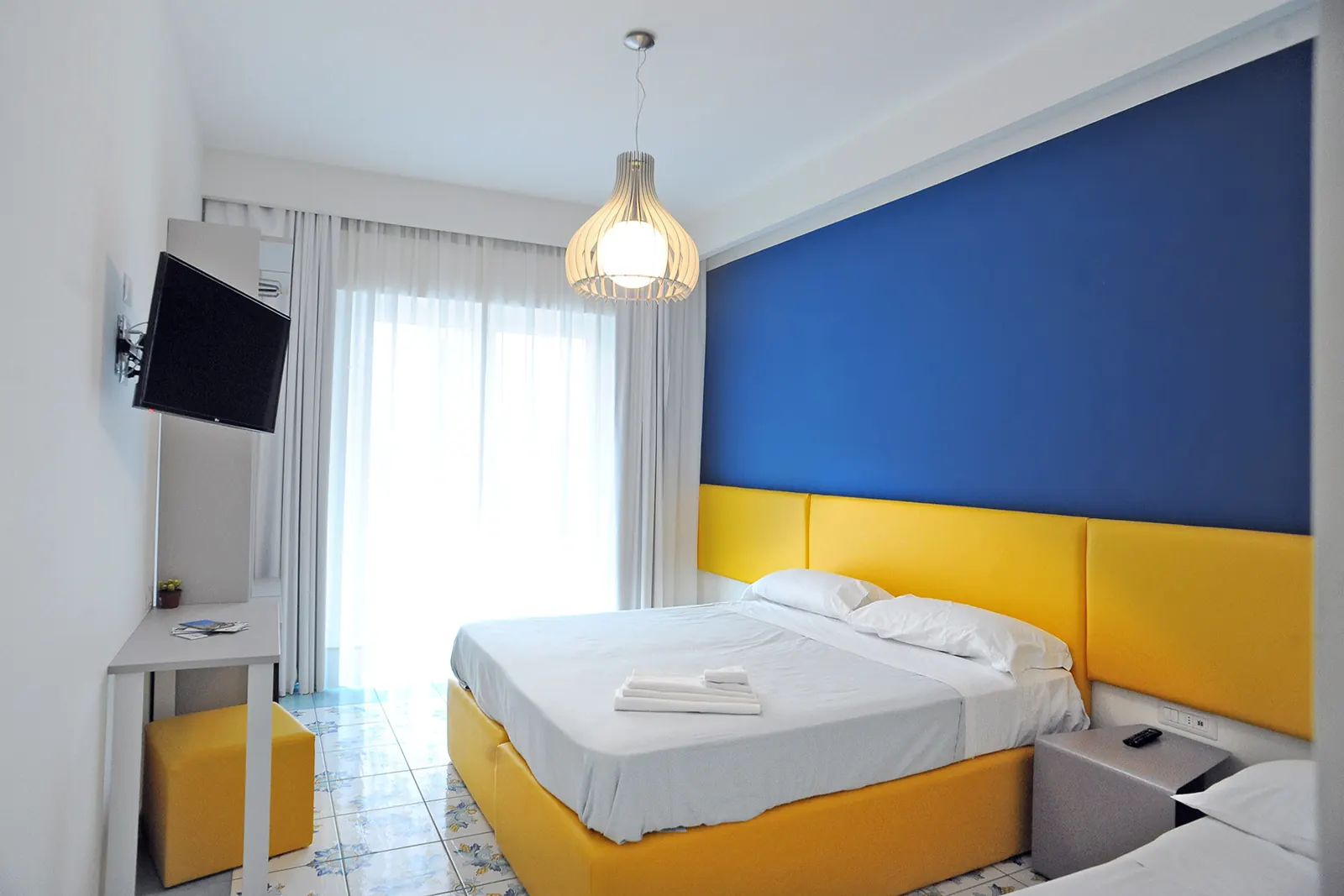 Camera con testiera blu e base gialla
